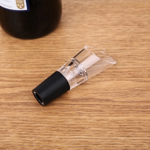 Close-up of a petal-shaped stainless steel wine aerator pourer on a wooden surface