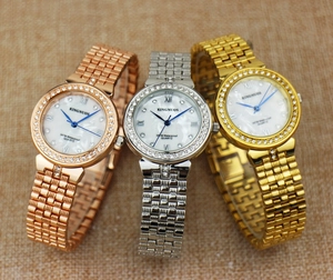 Detailed macro view of three diamond-set luxury watches in rose gold, silver, and gold
