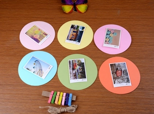 Close-up of colorful round paper photo frames with mini wooden clips and twine rope set