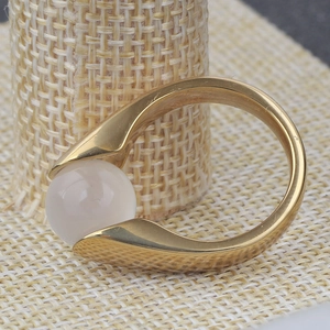 Macro detail of 18K gold-plated stainless steel ring with pink cat eye stone on burlap
