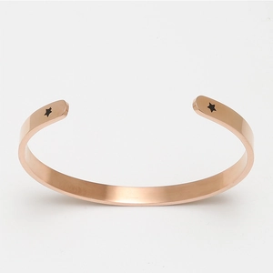 Rose gold open cuff bracelet with star engravings and I love you message on white background