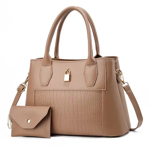 Detail view of taupe crocodile-embossed handbag set with gold lock hardware and strap
