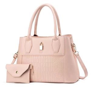Detailed macro view of pink handbag featuring crocodile pattern leather and gold lock