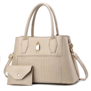 Detail of beige stone texture handbag with gold lock charm and matching small coin purse