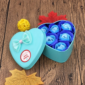 Macro shot of blue gradient soap roses inside a heart-shaped tin box with a bow
