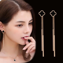 Detail of rose gold four-leaf clover necklace and matching tassel earrings set
