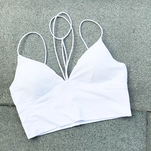 Detalle de crop top blanco con escote en V profundo y diseño de múltiples tirantes
