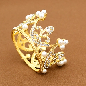 Detailed macro view of the golden crown cake topper with white pearls and crystals
