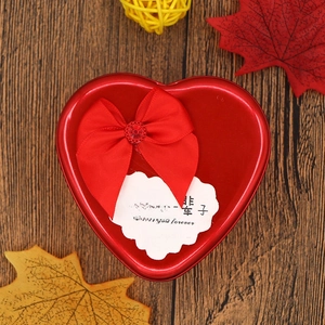Detail of red heart tin gift box with satin ribbon bow and ruby jewel embellishment