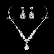 Macro detail of four-row diamond choker and teardrop earrings set on black background