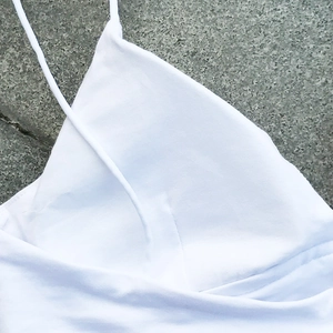 Vista detallada de los tirantes finos blancos de un crop top ajustado mujer