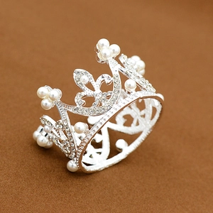 Detail of silver alloy mini crown with white pearls and sparkling rhinestones for cakes