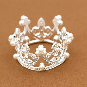 Macro detail of a silver alloy crown with sparkling rhinestones and white pearls