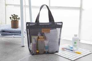 Borsa da viaggio grigia in rete con etichetta in pelle, in un bagno moderno