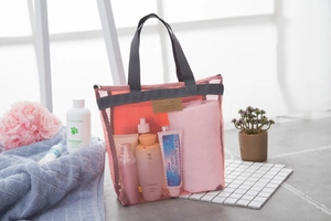 Vista dettagliata della borsa da viaggio in rete rosa con articoli da bagno e capienza