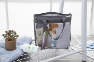 Dettaglio di una borsa da viaggio in rete grigia con maniglia e cerniera in bagno