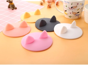 Close-up detail of cute cat ear silicone cup lids in various pastel colors on a table