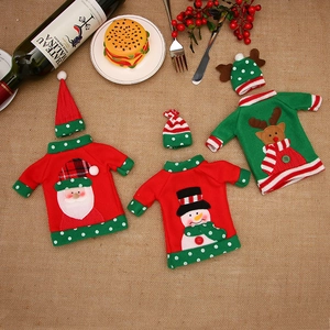 Three Christmas wine bottle covers with Santa, snowman and reindeer designs on burlap