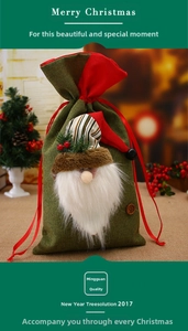Detail of green burlap Christmas gift bag with 3D Santa Claus and red ribbon drawstring
