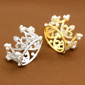 Detailed close-up of gold and silver mini crowns with embedded pearls and sparkling rhinestones