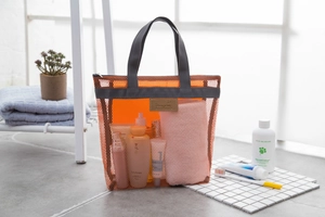 Dettaglio della borsa da viaggio in rete arancione con texture in nylon e manico