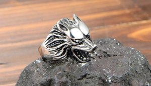 Vue latérale macro d'une bague tête de loup en acier inoxydable vintage sur pierre noire