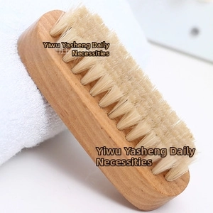 Detail of double-sided body brush with natural boar bristles and smooth wooden handle