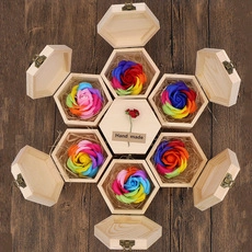 Detail view of hexagonal wooden gift boxes with soap roses and handmade tags on wood