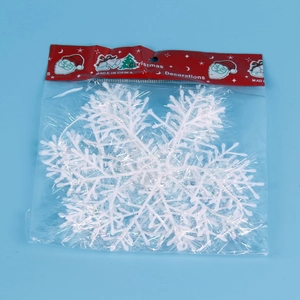 Detail of white iridescent snowflake ornaments in festive packaging on blue background