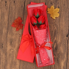 Detail of three red soap roses in a luxury gift box with elegant ribbon and dry flowers