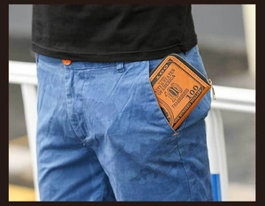Brown long wallet with dollar bill pattern tucked into a male user pocket