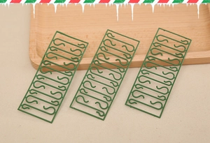 Detailed view of green plastic S-shaped hooks for hanging Christmas ornaments