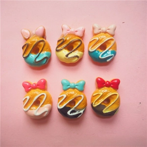 Detailed view of six resin donut charms with colorful bows for DIY phone case crafts