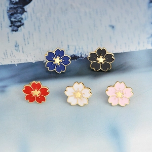 Macro detail of cherry blossom enamel pins in five colors with gold plated metal finish