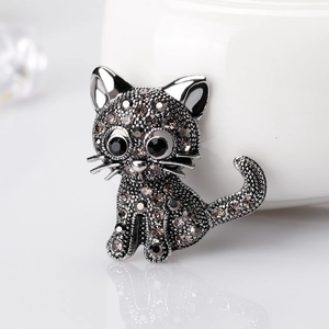 Retro cat brooch with dark grey rhinestones in a sitting pose on a white background