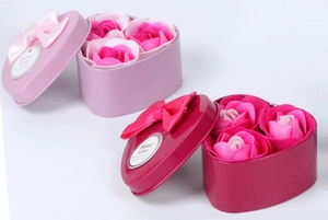 Detailed view of pink heart-shaped metal gift boxes featuring three soap rose flowers inside