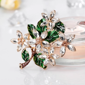 Elegant gold flower brooch with green enamel leaves and sparkling crystal petals