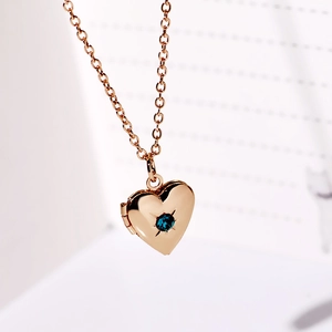 Collana con medaglione a cuore in oro rosa con una pietra di cristallo blu centrale