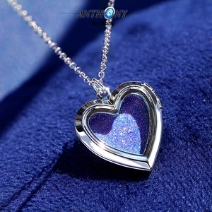 Macro view of silver heart locket pendant with glittery dark blue starry sky texture