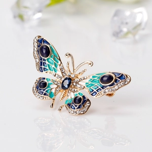 Elegant gold butterfly brooch with blue enamel wings and sparkling rhinestones