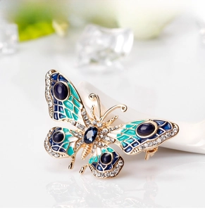 Macro detail of enamel butterfly brooch with blue glaze and sparkling white zircons