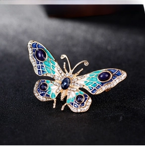 Macro shot of butterfly brooch featuring blue enamel wings and inlaid cubic zirconia