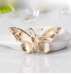 Macro detail of the butterfly brooch back with gold alloy texture and safety pin clasp