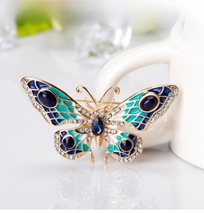 Close-up of enamel butterfly brooch with blue rhinestones and gold-tone details