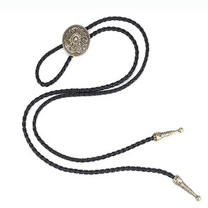 Detailed close-up of bronze Celtic floral engraving on a black bolo tie with metal tips