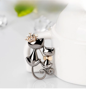 Détail macro d'une broche chat mignonne avec couronne en cristal sur tasse blanche