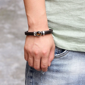 Brown leather bracelet with tiger eye stone and magnetic clasp on male wrist