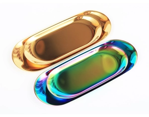 Top view of two oval metal trays in gold and rainbow mirror finishes on white background