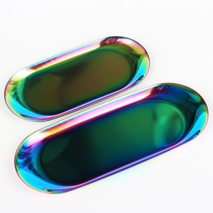 Set of two oval iridescent rainbow stainless steel storage trays on white background