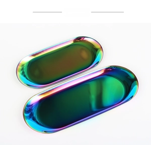 Close-up of two oval stainless steel trays with rainbow iridescent finish on white background